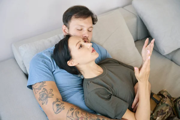 Young Couple Relaxing Sofa Bright Room Woman Emotionally Talking Man — Stockfoto