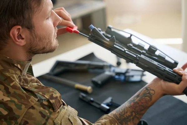 Handsome Military Man Sits Table Holds His Weapon His Hands —  Fotos de Stock