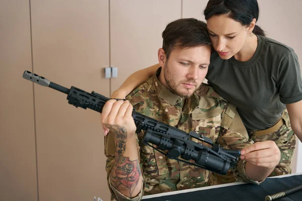 Serious Military Man Holds Weapon His Hands Examines Together Pretty —  Fotos de Stock
