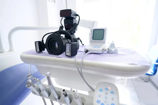 Modern digital camera lying on dental unit console in professional dentist office