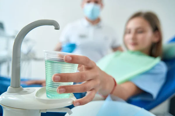 Female Patient Dental Chair Reaching Disposable Cup Mouthwash Presence Doctor — Stock Photo, Image