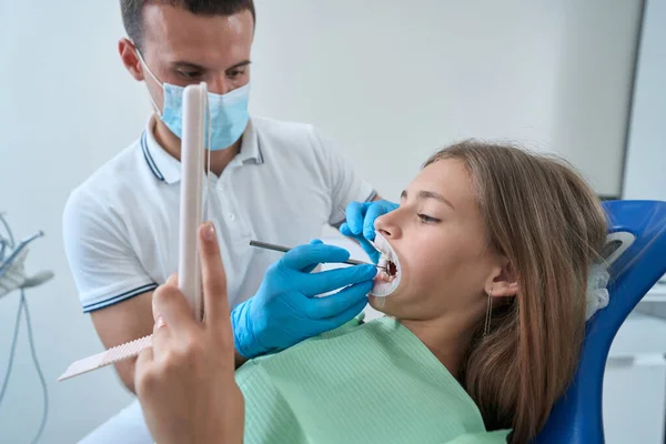 Adolescent Girl Looking Her Open Mouth Mirror While Pedodontist Inspecting — Foto Stock