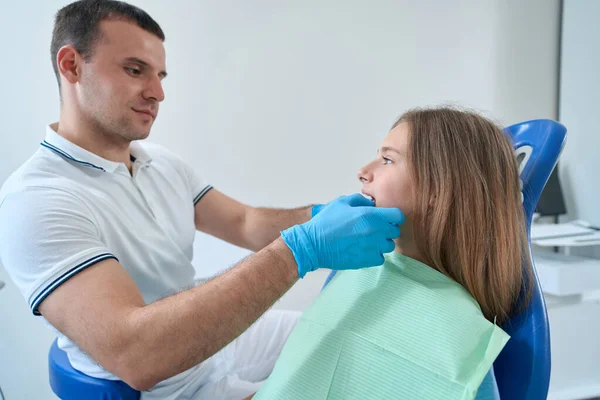 Calm Focused Orthodontist Performing Extraoral Examination Teenage Girl His Office — Zdjęcie stockowe