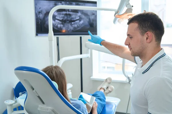 Professional Dentist Pointing Panoramic Ray Female Patient Seated Chair — Stockfoto