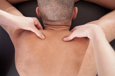 Close up of African American man receiving physical therapy massage in wellness center