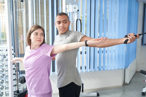 African American Man Stretching Arms Using Medical Kinesiotherapy Equipment While — Fotografia de Stock