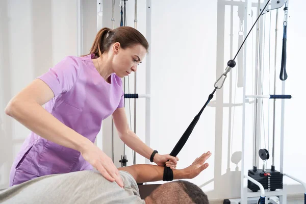 Man Using Kinesiotherapy Training Equipment While Doing Rehabilitation Exercise Female — Stock fotografie