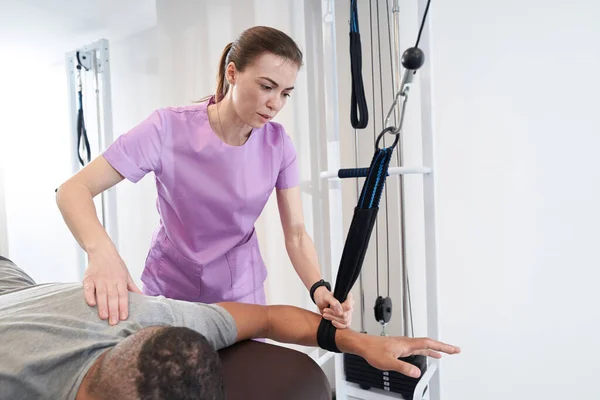 Male Patient Using Kinesiotherapy Training Equipment While Having Rehabilitation Procedure — 图库照片