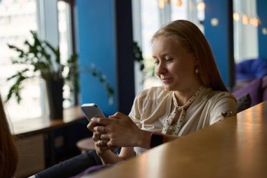 Gülümseyen bayan, aletin içeriğini iki eliyle tutarken izlemekten büyülenir.