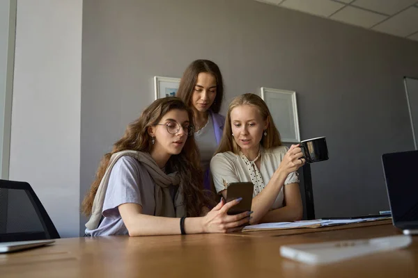 Entspannt Blicken Drei Frauen Auf Den Smartphone Bildschirm Während Eine — Stockfoto