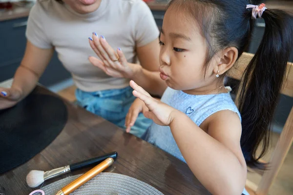 妈妈坐在餐桌旁 双手整齐 教她勤勉的女儿修指甲 — 图库照片