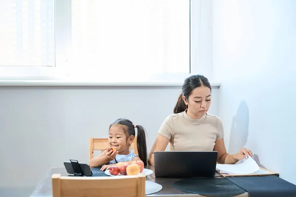 Young Mother Works Laptop Her Daughter Sits Next Table Watches — Stock Photo, Image