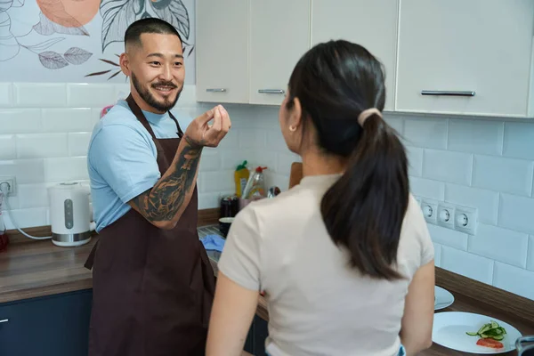 Kollarında Dövmesi Olan Gülümseyen Asyalı Adam Mutfakta Kuyruklu Bir Kadına — Stok fotoğraf