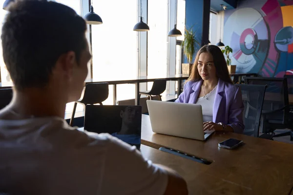 Serieuze Vrouw Hand Hand Laptop Toetsenbord Terwijl Man Zit Tegenover — Stockfoto