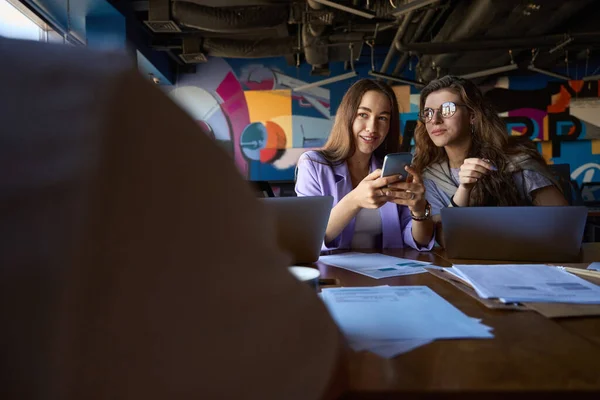 Vrouwen Zitten Zij Aan Zij Aan Tafel Kijken Naar Man — Stockfoto