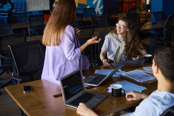 Joyful Vrouw Zit Aan Een Bureau Tegenover Een Man Terwijl — Stockfoto