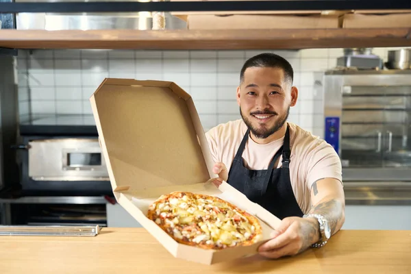 Homem Amigável Uniforme Chef Sorrindo Enquanto Segura Uma Caixa Papelão — Fotografia de Stock