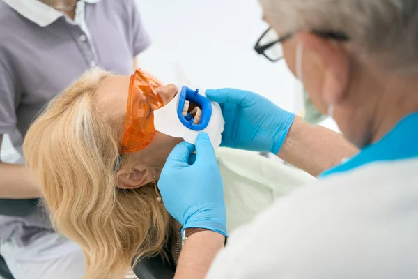 Een Vrouw Beschermende Brillen Whitening Van Tanden Tandheelkundige Kliniek Schouderaanzicht — Stockfoto