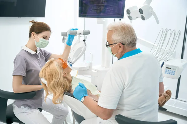 Οδοντίατρος Και Βοηθός Κάνει Λεύκανση Των Δοντιών Για Τον Ασθενή — Φωτογραφία Αρχείου