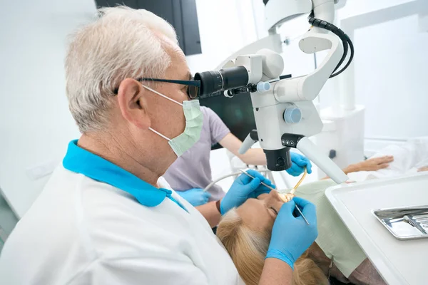 Κοντινό Πλάνο Του Γιατρού Κάνει Χειρουργική Επέμβαση Δοντιών Στο Μικροσκόπιο — Φωτογραφία Αρχείου