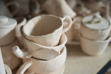 Ahşap bir rafta birçok farklı cam kap ve kâse var.