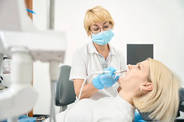Οδοντίατρος Δουλεύει Στο Γραφείο Του Ένα Τρυπάνι Στα Χέρια Του — Φωτογραφία Αρχείου