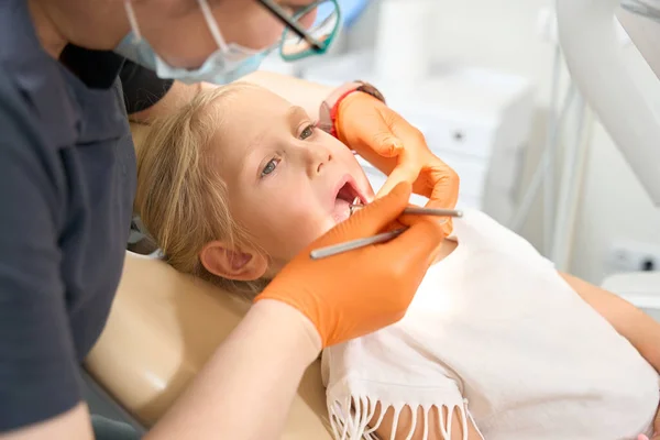 治療中に口が開いている子供は歯医者の椅子に座っています — ストック写真