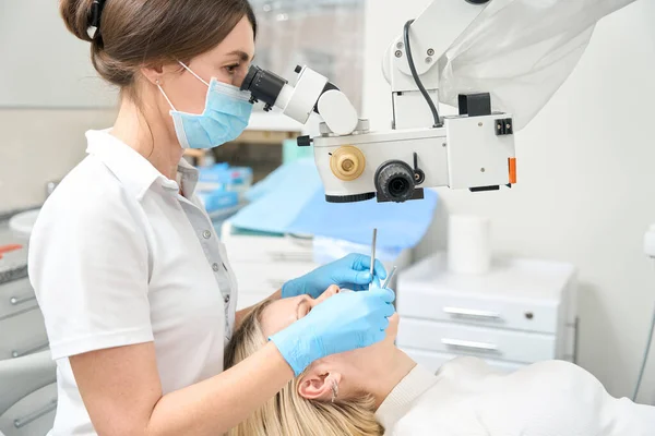 Lekarz Siedzący Kanapie Bada Zęby Pacjenta Patrząc Potężny Mikroskop — Zdjęcie stockowe