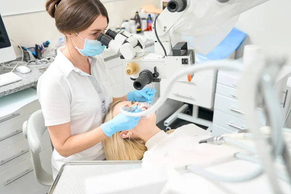 Femme Dentiste Regardant Dans Microscope Effectue Procédure Brossage Des Dents — Photo