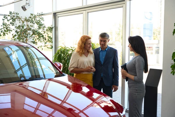 Nice Couple Inspecting Car Salon Accompanied Pretty Woman Manager Tablet — Stock Photo, Image