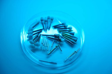 Dişleri şeffaf yuvarlak bir konteynırda cilalamak için kullanılan diş aletleri.