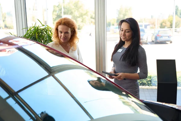 Young Woman Manager Car Dealership Consults Pretty Red Haired Customer — Stock Photo, Image