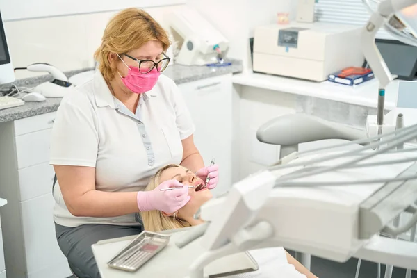 Médecin Dentiste Lunettes Masque Rose Traite Les Dents Une Patiente — Photo