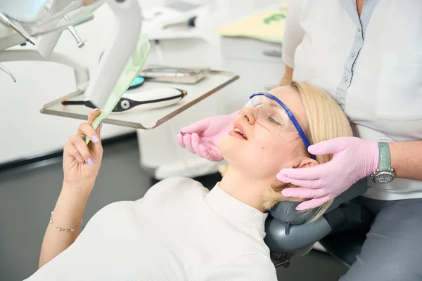 Pacient Sedí Křesle Dívá Své Zuby Zrcadle — Stock fotografie