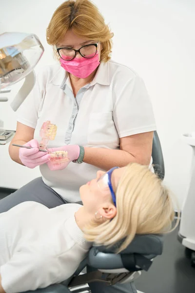 Caucasian doctor shows a bad tooth on the jaw mockup