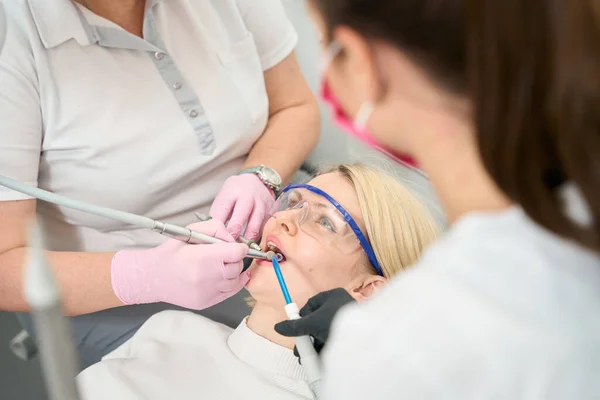 Kobieta Białymi Włosami Otwartymi Ustami Leczona Kanałami Dentystycznymi Przez Dwóch — Zdjęcie stockowe