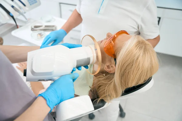 Mavi Eldivenli Hemşirenin Arka Plan Portresi Klinikteki Diş Röntgenlerinin Fotoğrafını — Stok fotoğraf