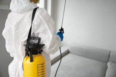 Beyaz üniformalı temizlik şirketinden gelen dezenfeksiyon için sarı enstrüman.