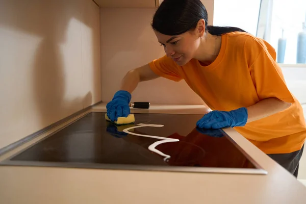 Jonge Vrouw Uniform Staan Buurt Van Tafel Keuken Schoonmaken Inductie — Stockfoto