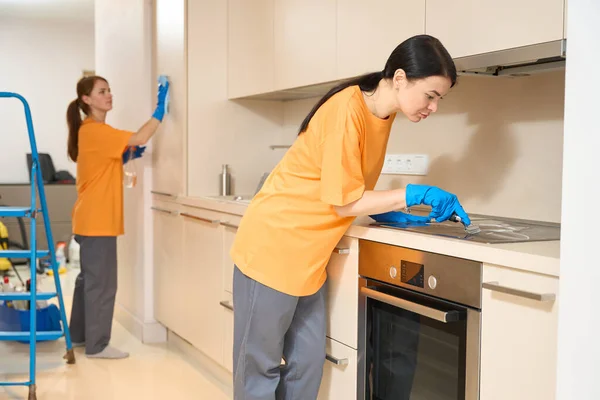 Jonge Dames Uniform Zijn Schoonmaakoppervlakken Van Keukenkastje Oven Met Wasmiddelen — Stockfoto