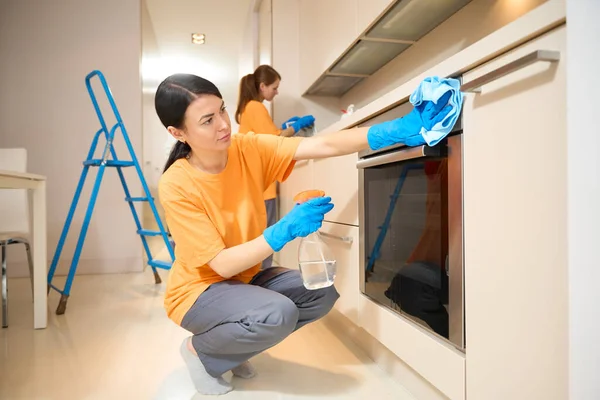 Vrouw Zit Buurt Van Oven Veegt Het Met Spray Voor — Stockfoto