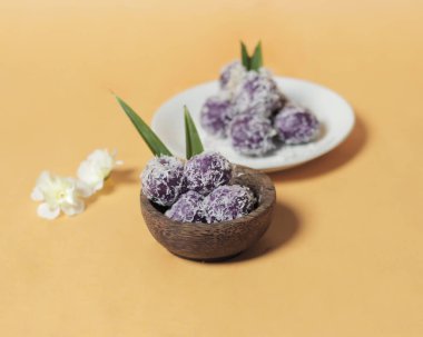 Kahvaltıdan sonra atıştırmak için mor patates kleponu. Klepon 'un tatlı bir tadı ve yumuşak ve çiğnenebilir bir dokusu var. Bu pastanın içinde genellikle fıstık ya da esmer şeker olur. Market atıştırmalıkları. Odak bulanıklığı.