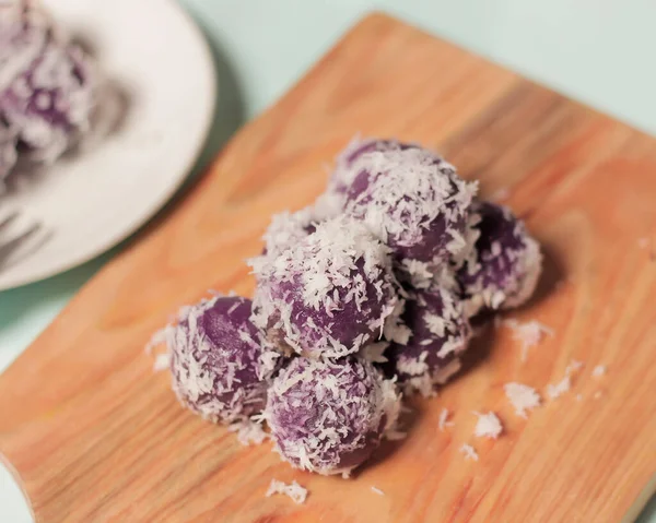 Purple sweet potato klepon for an after breakfast snack. Klepon has a sweet taste and a soft and chewy texture. This cake usually has a peanut or brown sugar filling. market snacks. Focus blur.