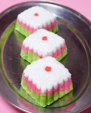 Putu Ayu keki üç renk içeren bir kutu şeklinde, yani yeşil, kırmızı ve beyaz. Bu pastanın yumuşak ve yumuşak bir dokusu var. Putu Ayu marketlerde ya da dükkanlarda bulunabilir. Market atıştırmalıkları. Odak bulanıklığı.