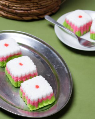 Putu Ayu keki üç renk içeren bir kutu şeklinde, yani yeşil, kırmızı ve beyaz. Bu pastanın yumuşak ve yumuşak bir dokusu var. Putu Ayu marketlerde ya da dükkanlarda bulunabilir. Market atıştırmalıkları. Odak bulanıklığı.