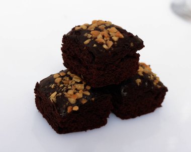 Yumuşak ve kalın çikolatalı kek dokusu. Kare şeklinde pişirilmiş ya da buğulanmış yiyecekler. Çikolata aromalı ve bol fındıklı. Odak bulanıklığı.