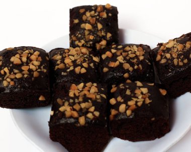 Yumuşak ve kalın çikolatalı kek dokusu. Kare şeklinde pişirilmiş ya da buğulanmış yiyecekler. Çikolata aromalı ve bol fındıklı. Odak bulanıklığı.