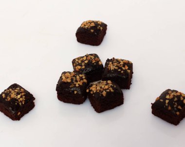 Yumuşak ve kalın çikolatalı kek dokusu. Kare şeklinde pişirilmiş ya da buğulanmış yiyecekler. Çikolata aromalı ve bol fındıklı. Odak bulanıklığı.