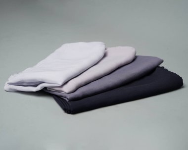 Gri arkaplana düzgünce yerleştirilmiş çıplak renkli peçeler. Müslüman kadınlar için kullanılmaya hazır gri renkli ince kumaş karışımı. Satış gösterileri için de kullanılabilir. Odak bulanıklığı. tesettür.