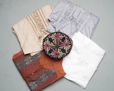 Çeşitli motif ve renklere sahip Müslüman erkek kıyafetleri ibadet için çok uygundur. Bayramdan önce Ramazan ayında moda gereksinimleri. Odak bulanıklığı. Müslümanların moda modeli. Bayram ve müdik için yeni kıyafetler.